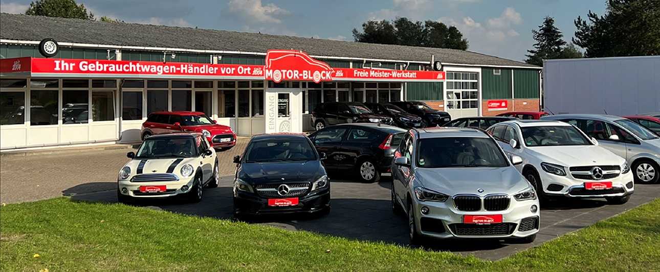 Gebrauchtwagen mit Firmengebäude im Hintergrund